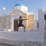 Woman in a warrior pose on a church wall in Greek Islands