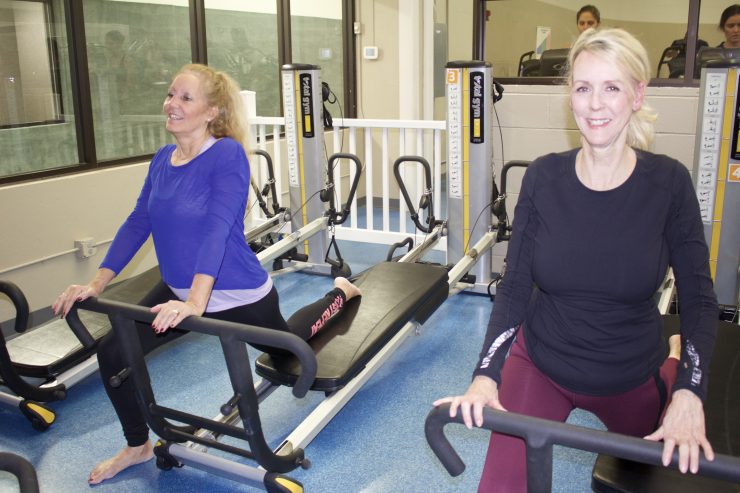 Two women on Total Gym machines in Total Body Pilates at Monroe County Southwest YMCA