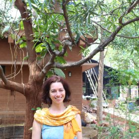 Yulia in harmony with nature: standing in front of a mango tree in a natural setting at Vaidyagrama Healing Village